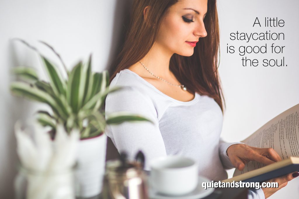An introverted woman embraces stagnation during her staycation, finding solace in a book.