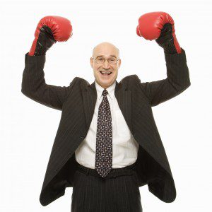 A businessman in a suit showcasing boxing gloves in Gallery 1.