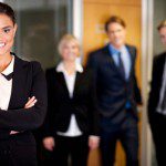 A group of business people Fake It 'til You Make It standing in front of an office.
