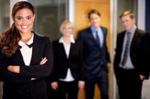 A group of business people Fake It 'til You Make It standing in front of an office.