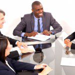 A group of business people calmly sitting around a conference table.