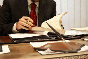 A man in a suit staying calm and focused while reading a book.