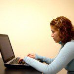 A woman using a laptop to comment on blogs.