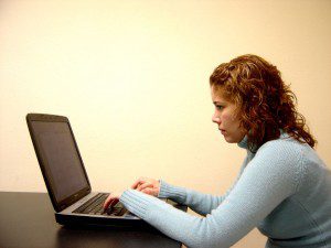 A woman using a laptop to comment on blogs.