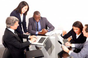 A group of energized business people sitting around a table, brainstorming and thinking.