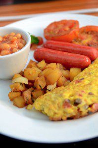 A satisfying plate of food featuring an omelet, beans, and toast that you know you'll like.