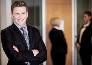 A businessman exudes quiet confidence as he stands in front of a group of people.