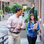 Two business people building relationships while walking down an alleyway.