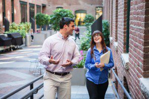 Two business people building relationships while walking down an alleyway.
