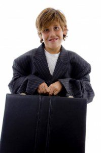 A young boy in a suit holding a briefcase exuding confidence and professionalism.