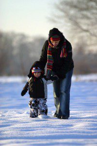A woman and child, reflecting on nature vs nurture, silently explore the snow-covered landscape.