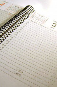 A spiral notebook is open on a white surface for a weekly review.
