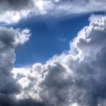 A cloudy sky highlighting a little patch of blue pierced by rays of light.