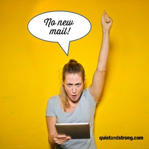 A telecommuting woman holds up a tablet displaying a speech bubble indicating no new emails.