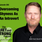A man in a black shirt stands next to text promoting episode 265 of The Quiet and Strong Podcast about overcoming shyness as an introvert, hosted by David Hall.